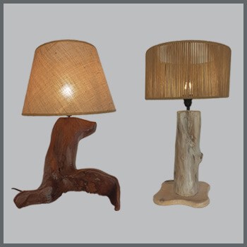 Φωτογραφία δύο μοντέρνων επιτραπέζιων φωτιστικών με βάση από φυσικό ξύλο σε φυσικό χρώμα και σε λευκό χρώμα και καπέλα από λινάτσα και φυσικό σχοινί αντίστοιχα, από τη βιοτεχνία αμπαζούρ και φωτιστικών Gekas Luminoso.